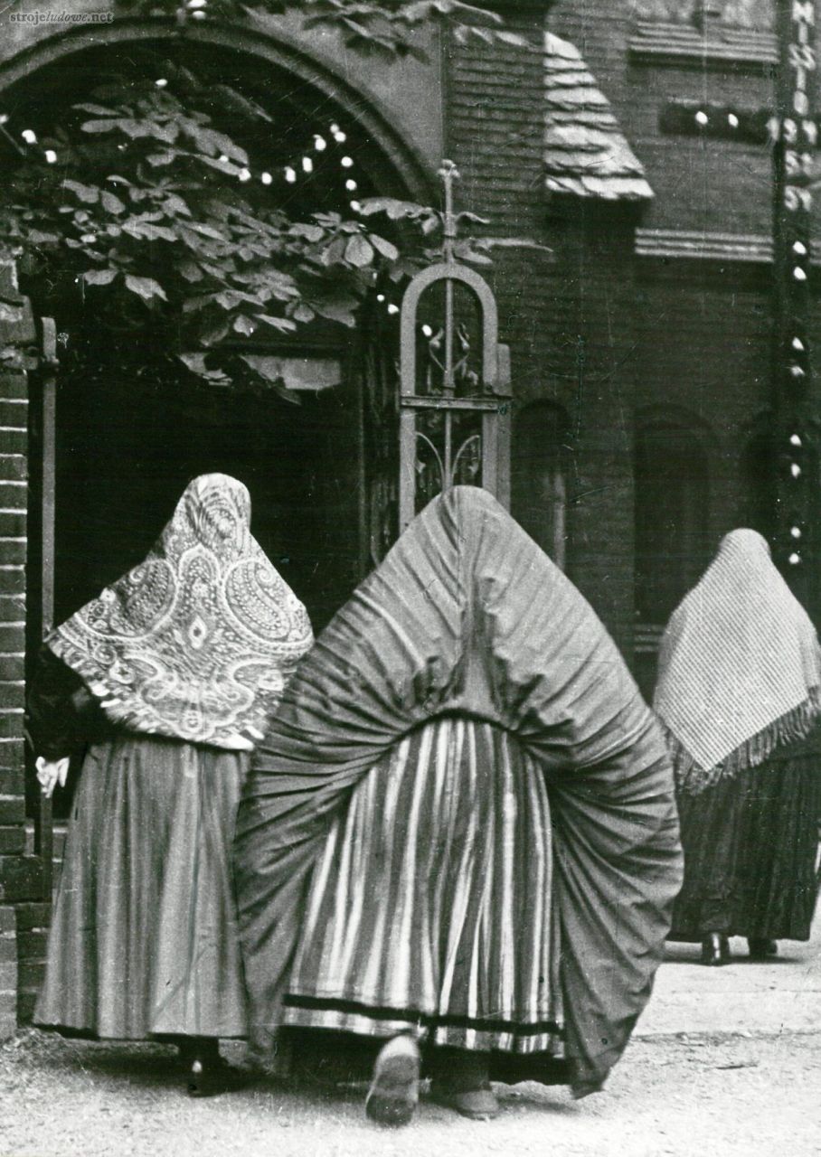 Kobieta osłaniająca się kiecką w&nbsp;czasie deszczu, Dąbrówka Wielka (Piekary Śląskie), 1954&nbsp;r., fot. Barbara Bazielich. Ze&nbsp;zbiorów Muzeum Górnośląskiego w&nbsp;Bytomiu.-