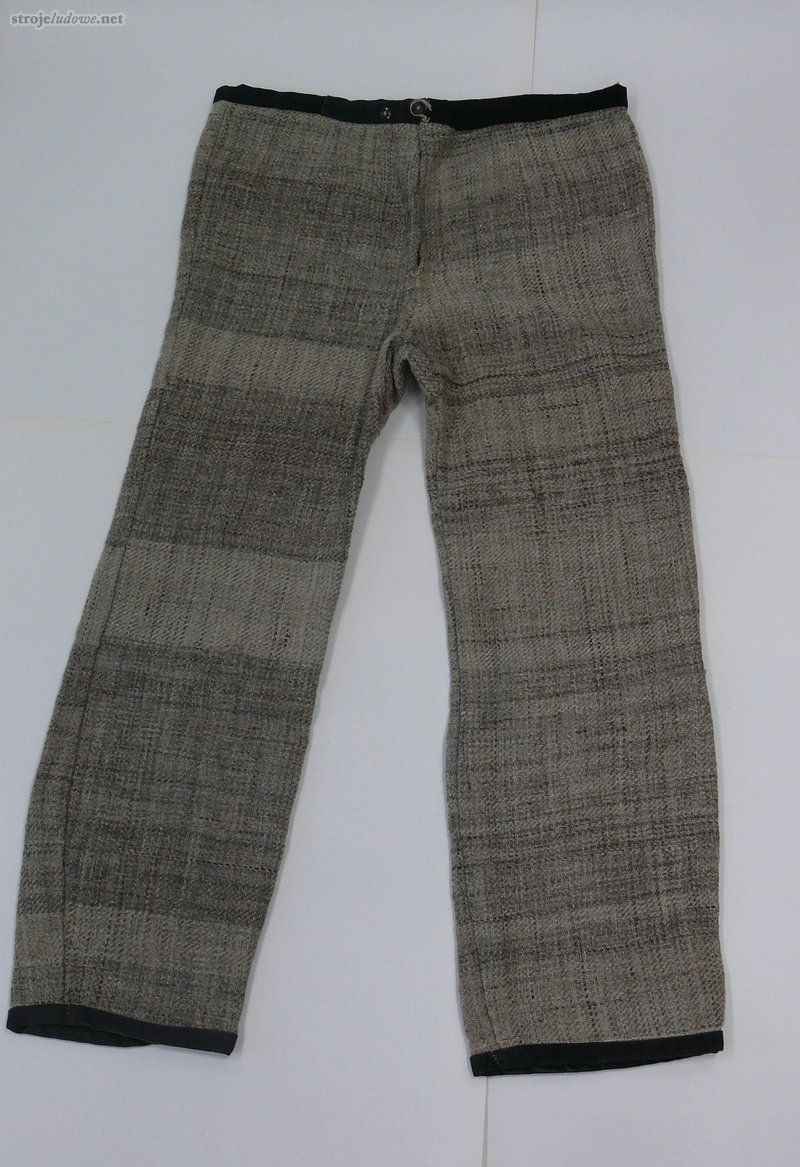 Spodnie z tkaniny samodziałowej, lata 60. XX w., ze zbiorów Muzeum Północno-Mazowieckiego w Łomży, fot. W. Pawlak

Do stroju codziennego, jeszcze w latach 50.XX w., noszono spodnie o prostym kroju, szyte z wełniano- lnianej tkaniny samodziałowej. Natomiast do stroju odświętnego, po 1890 roku zamożniejsi zakładali spodnie <em>sztuczkowe</em> (czyli szyte z tkaniny w szaro-czarne paski) o niezbyt szerokich, sięgających do kostki nogawkach. Zgodnie z zasadami obowiązującej mody noszono je z kamizelką i marynarką.