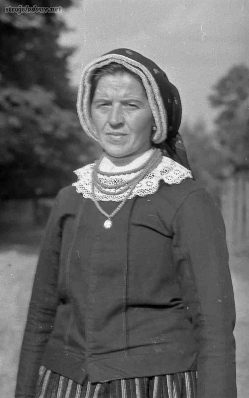 Mężatka w czepcu, Wieluńskie, 1957 r. Archiwum Etnograficzne Muzeum Archeologicznego i Etnograficznego w Łodzi, fot. K. Wecel

Najbardziej rozpowszechniony był czepiec pod chustę. Składał się z batystowej główki, ściągniętej sznureczkiem z tyłu głowy oraz ze sztywnych, tiulowych falbanek, okalających główkę, którą ozdabiano tzw. <em>wypuścikami</em>, tzn. kawałkami różowej lub niebieskiej wstążki. Główka czepca była przykryta wzorzystą chustką, której końce zawiązane były na czole lub zwisały z tyłu.