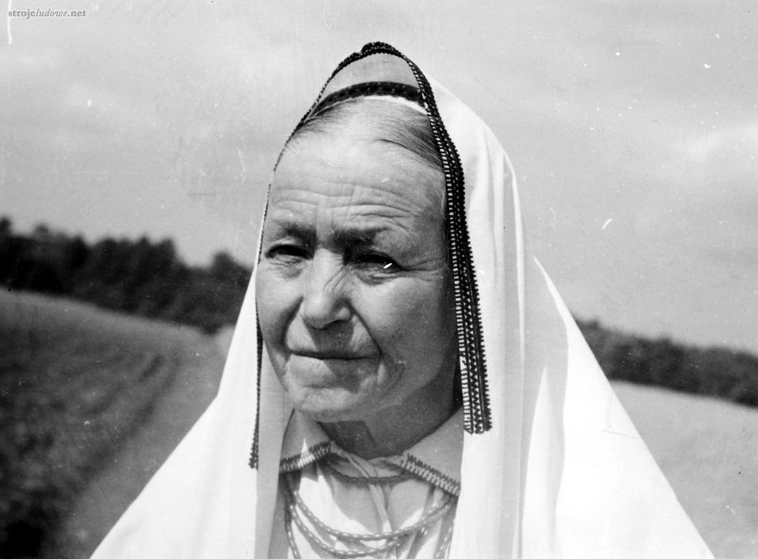 Kobieta w <em>nakrywce</em> i <em>chamełce z zatyczką</em> fot. B. Czarnecki, 1956 r., Archiwum Naukowe Państwowego Muzeum Etnograficznego w Warszawie

<em>Nakrywka</em>, <em>płachta</em>, <em>zawicie</em> to prostokątny płat samodziału lnianego lub bawełnianego płótna fabrycznego o wymiarach ok. 70 cm x 220 cm. Wzdłuż węższych boków zdobi <em>nakrywkę</em> fabryczna koronka i niekiedy wąski szlaczek haftu liczonego, a przy jednym z boków dłuższych haft bardziej rozbudowany, rozmieszczony wzdłuż środkowej części tego boku  tzn. w części okalającej twarz. W obu wypadkach  haft jest w kolorze czerwonym lub czarnym i ma kształt pasowy. <em>Nakrywkę</em> noszono na <em>chamełkę</em> z <em>zatyczką</em> lub <em>oberek</em>. Zarzucano ją na głowę (środek dłuższego boku ozdobiony haftem znajdował się nad czołem), tak że okrywała ramiona i ciało kobiety sięgając aż po kolana. Stanowiła całoroczny element stroju obrzędowego kobiet zamężnych.