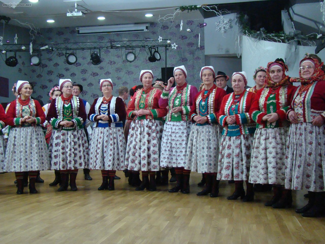 Członkinie Regionalnego Zespołu Pieśni i Tańca „Wilamowice” prezentujące w czasie występu różne rodzaje fartuchów, Wilamowice 2012, fot. Rafał Sznajder

Każda spódnica z przodu zasłaniana była fartuchem o odpowiednim wzorze, stąd też często spotyka się spódnice, które z przodu uzupełnione są innym, tańszym materiałem.  Do odświętnych kompletów zakładano fartuchy z zielonej tafty lub jedwabiu. Popularnymi są fartuchy z białego płótna, zdobione kwiecistymi nadrukami. Wielkość kwiatów determinowała ponownie okazja na jaką był on zakładany – fartuch w duże róże (<em>puśkjyśy śjyctüh</em>) był uznawany w hierarchii zaraz po zielonym.