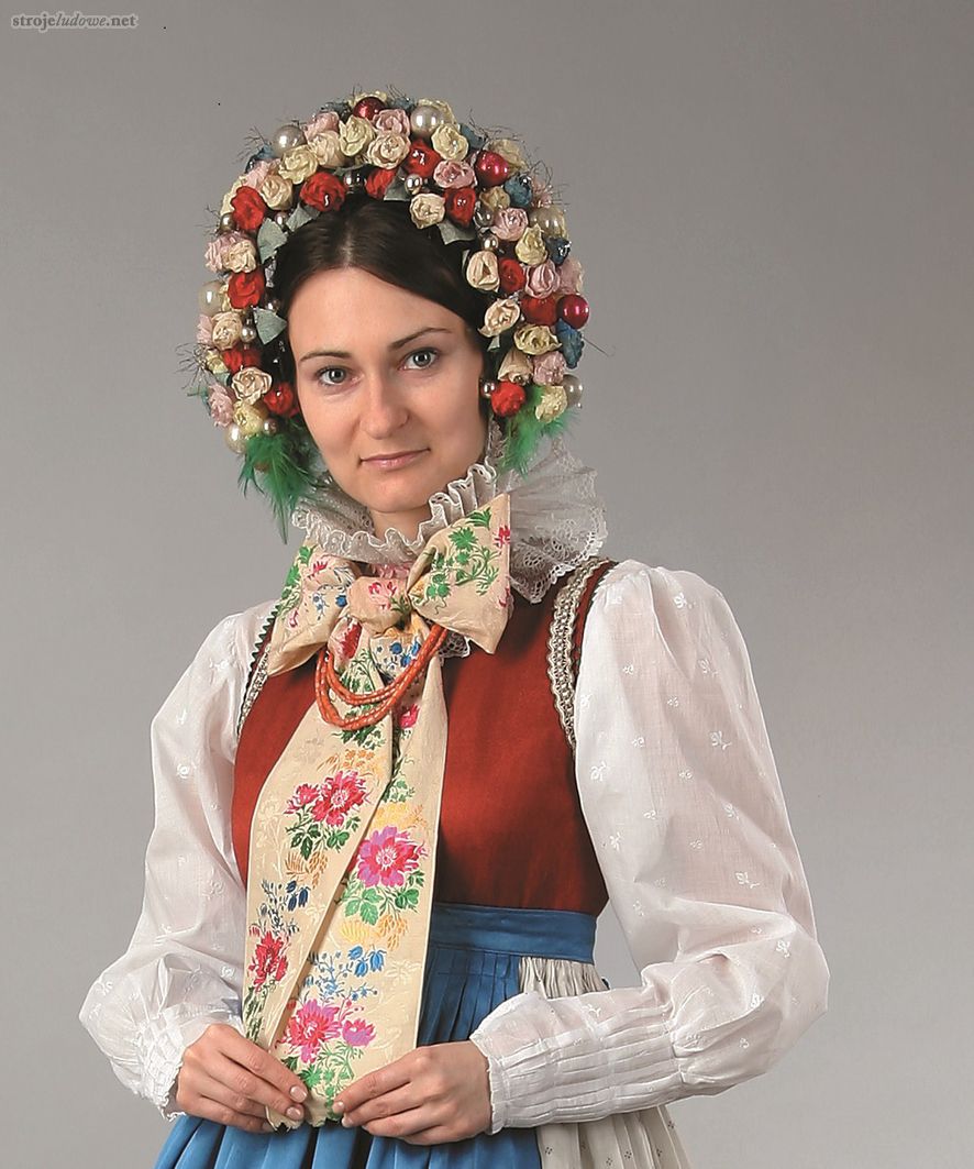 Obrzędowe nakrycie głowy druhny, Dąbrówka Wielkopolska, I poł. XX w. Ze zbiorów Muzeum Etnograficznego Oddział Muzeum Narodowego w Poznaniu, aranżacja na modelce E. Sobiak, fot. A. Cieślawski




Bukiety mają kształt diademu, który tworzy kilka rzędów połączonych ze sobą i usztywnionych drutem sztucznych kwiatów, najczęściej pąków róży. Pomiędzy kwiaty wplatane są szklane bombki, pocięty staniol, złoty lub srebrny szych. Wianek ten zakłada się w specyficzny sposób, tak że okala twarz od wierzchołka głowy, aż poniżej uszu, a przymocowane na jego końcach kolorowe pióra (czerwone, zielone, niebieskie) sięgają aż do ramion.