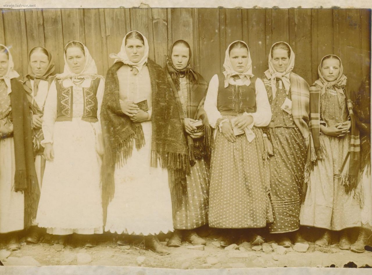 Góralki z Pcimia w strojach odświętnych ok. 1912 r.
Dziewczęta mają gorsety i białe koszule z mankietami lub wizytki. Na ramionach zdobione frędzlami łoktuse wykonane z różnorodnych tkanin. Spódnice uszyte z farbowanego płótna (farbowanice, druki orawskie) w drobny deseń. Dwie (3. i 4. od lewej) posiadają dodatkowo białe zapaski z ząbkami przy dolnej krawędzi. Dopełnieniem stroju są chustki zawiązane pod brodą, korale oraz skórzane buty. Archiwum Muzeum Etnograficznego w Krakowie