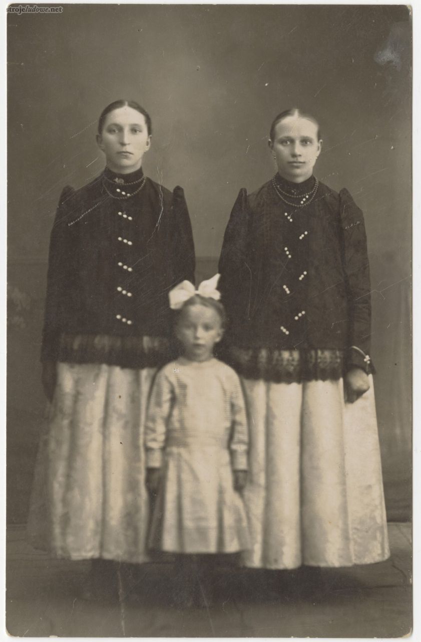 Fot. 18.	 
Portret trzech sióstr, dwie starsze ubrane w stroje pszczyńskie, jakle różni układ guzików (służyły one jedynie ozdobie, zaś sama jakla zapinana była na zatrzaski bądź haftki), powiat pszczyński (miejscowość niezidentyfikowana), lata 20-30. XX w., autor nieznany, z kolekcji Muzeum Śląskiego w Katowicach.
