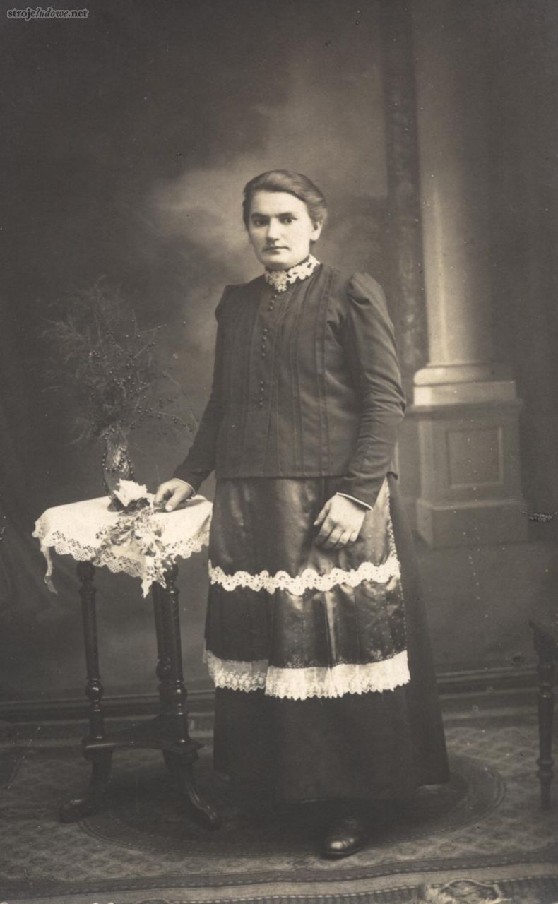 Kobieta z&nbsp;powiatu oleskiego, lata 20. XX&nbsp;w., fot. Fototeka Śląska (Muzeum Wsi Opolskiej).
Strój noszony na&nbsp;całym Śląsku Opolskim od&nbsp;początku XX&nbsp;w. składał się z&nbsp;kiecki oraz nałożonej na&nbsp;nią jakli i&nbsp;fartucha. Suknia – miderok, mazelonka szyta była z&nbsp;ciężkiej tkaniny i&nbsp;miała krój bezrękawnika, dzięki czemu była wygodniejsza w&nbsp;noszeniu. Jakla zapinana wysoko, u&nbsp;dołu sięgała przynajmniej bioder. Zdobiona była przeszyciami, guzikami, oraz <em>maszynową</em> pasmanterią. Fartuch szyto z&nbsp;tkanin jedwabnych – gładkich atłasów, adamaszków i&nbsp;również zdobiono haftem i&nbsp;taśmami pasmanterii. Wszystkie użyte tkaniny były produkcji fabrycznej.
