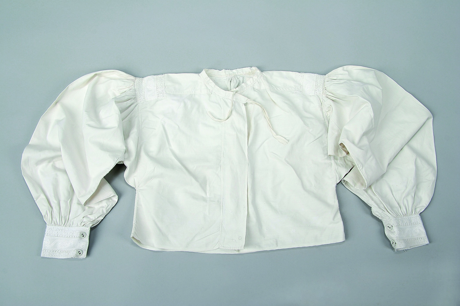 Koszulka z płótna, zdobiona na mankietach i ramionach białą koronką fabryczną, Dąbrówka Wielkopolska, I połowa XX w. Ze zbiorów Muzeum Etnograficznego Oddział Muzeum Narodowego w Poznaniu, fot. A. Cieślawski




Koszule kobiece miały w tym regionie krój poncho podłużnego. Szyto je z trzech gatunków płótna samodziałowego. Z najgrubszego wykonywano nadołek (czyli niewidoczną, dolną część), odcinek okalający plecy i piersi (mało eksponowany, bo osłonięty kaftanem lub stanikiem) szyto z samodziału średniej jakości, a rękawy (niekiedy w pełni widoczne) z płótna najcieńszego i najlepiej bielonego. Koszule przy szyi były wykończone niewielką stójką, mogły mieć długie lub krótkie rękawy. Ich zdobienia ograniczały się do marszczeń, a niekiedy także skromnego, białego haftu na ramionach.