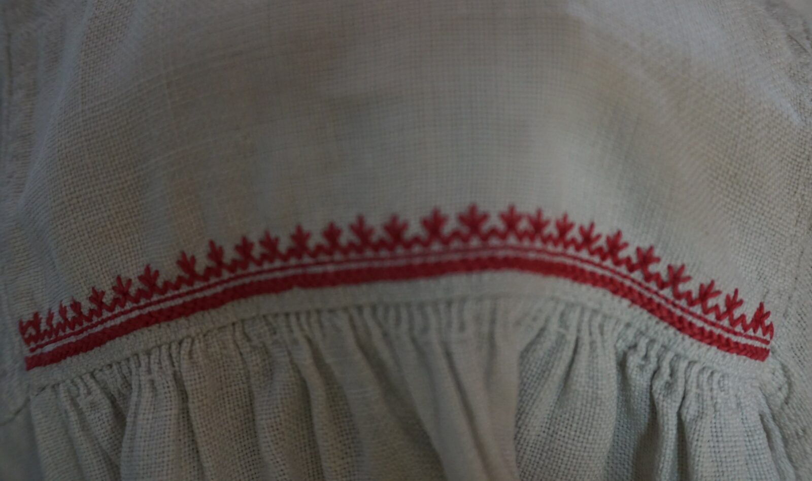 Haft płaski czerwony na&nbsp;przyramku koszuli kobiecej. Zbiory Muzeum Regionalnego im. Stanisława Sankowskiego w&nbsp;Radomsku, fot. Barbara Sitek.