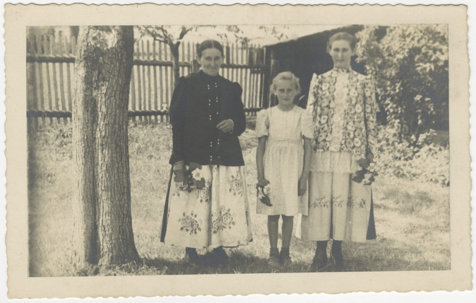 Fotografia rodzinna, matka z&nbsp;dwiema córkami sfotografowana w&nbsp;ogrodzie – matka oraz starsza córka ubrane w&nbsp;stroje pszczyńskie, powiat pszczyński (miejscowość niezidentyfikowana), lata 30. XX&nbsp;w., autor nieznany, z&nbsp;kolekcji Muzeum Śląskiego w&nbsp;Katowicach.